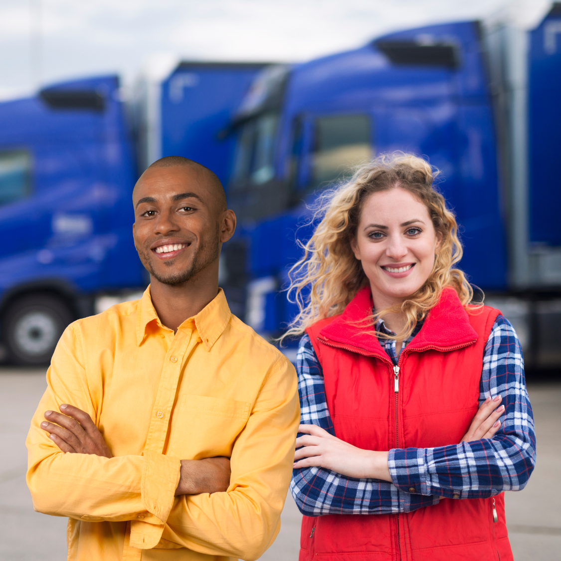 man and woman standing in front of large trucks