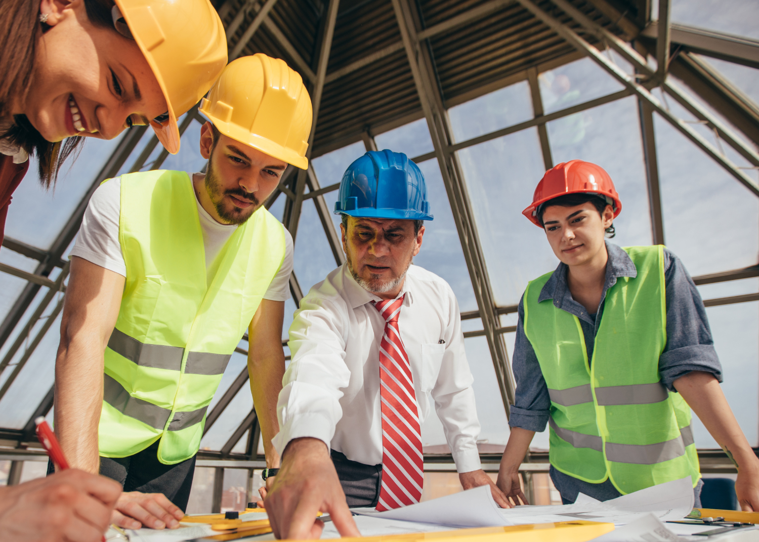 construction workers standing over blueprints