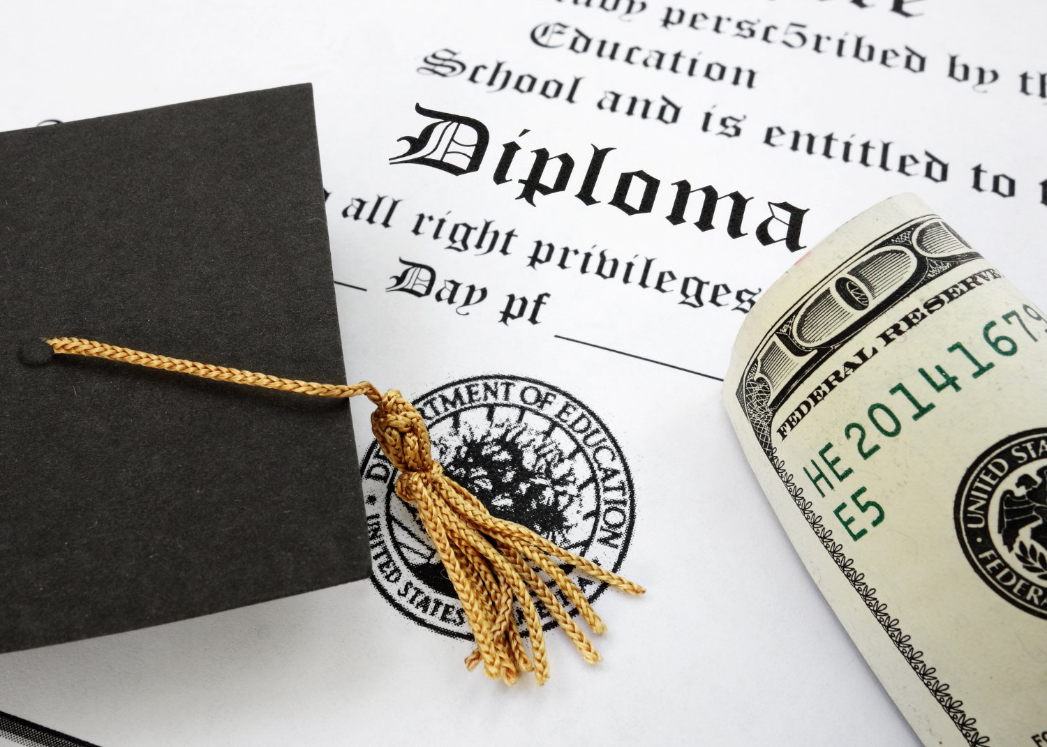 graduation cap next to money and a diploma