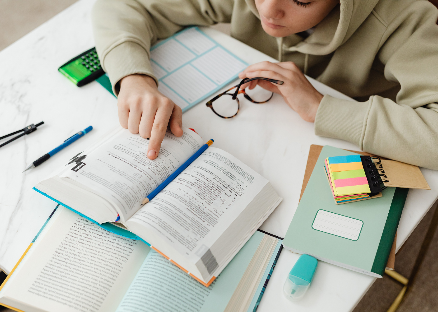 student sitting at desk studying textbooks