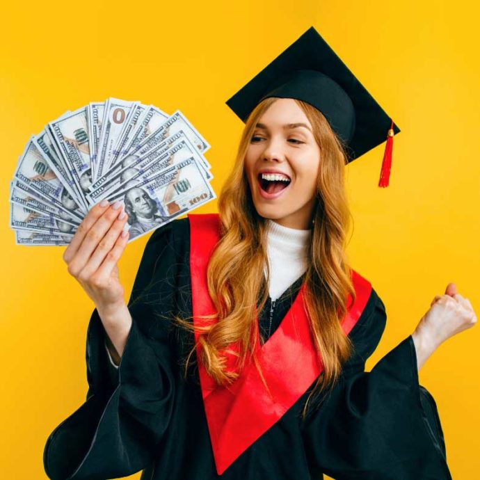 Girl in graduation cap and gown holding hundred dollar bills and celebrating
